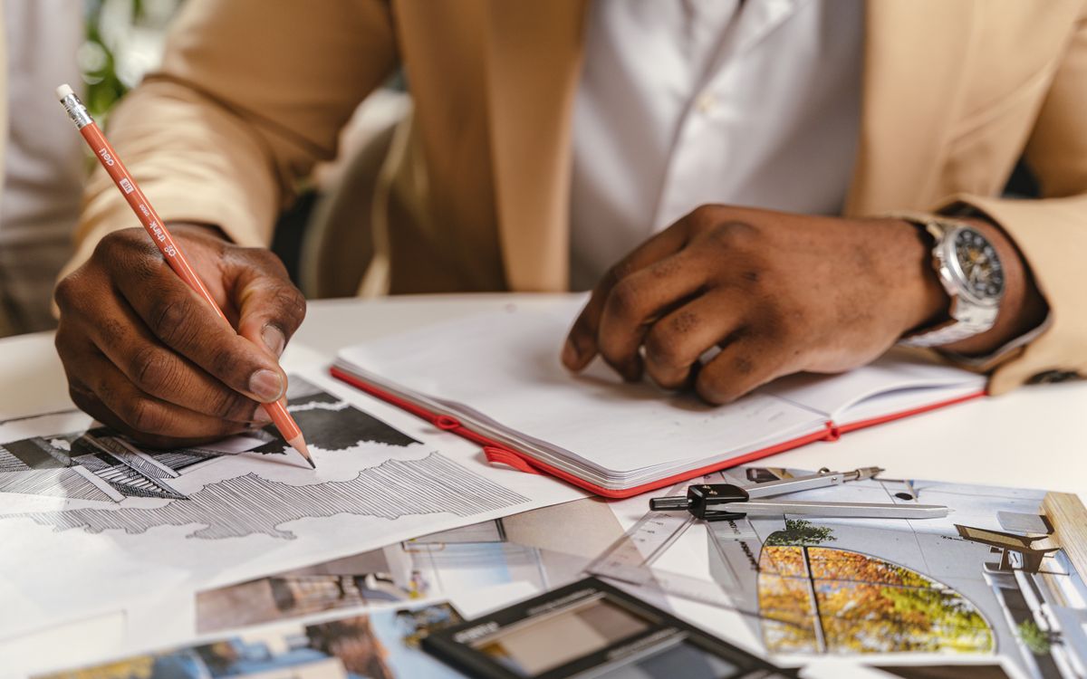 Architect sketching plans beside a drafting ruler