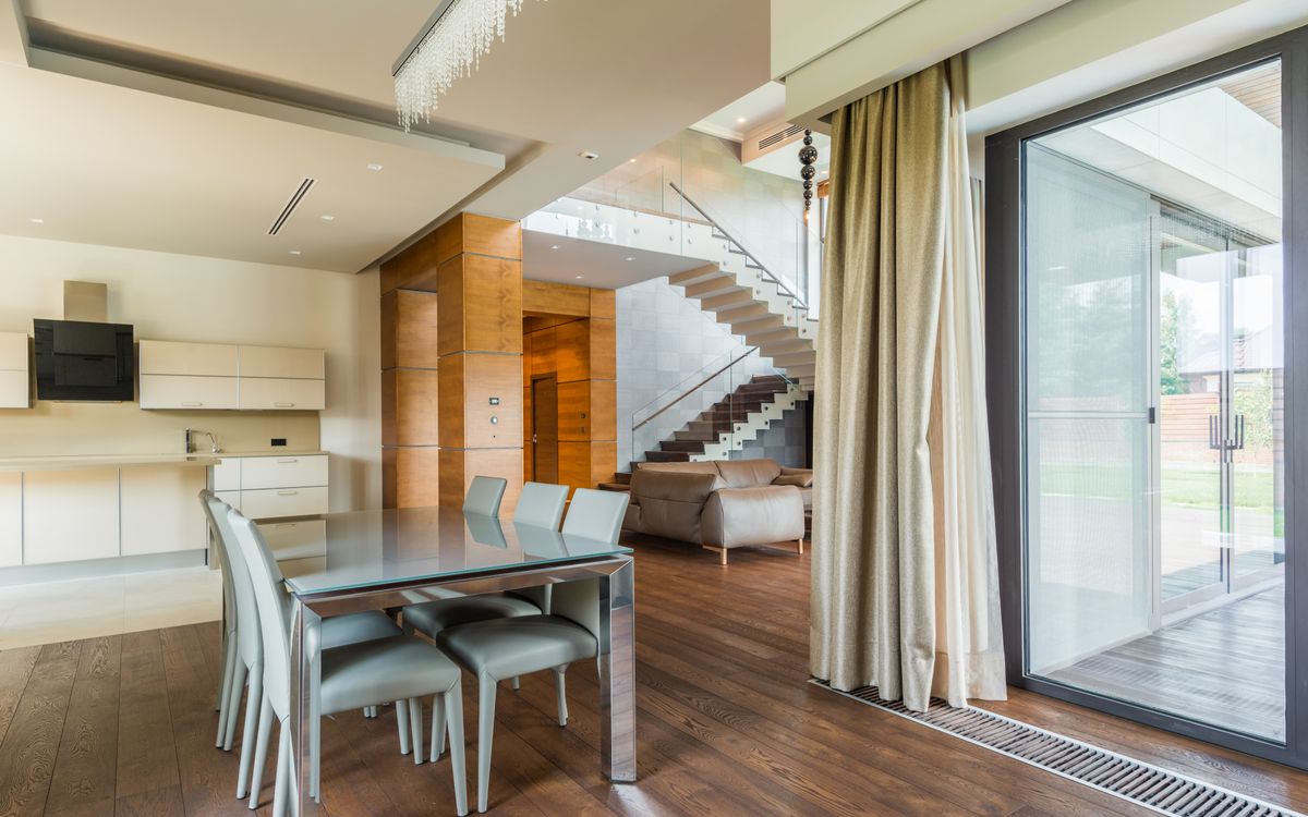 Dining room opening onto a terrace through full-height glass doors