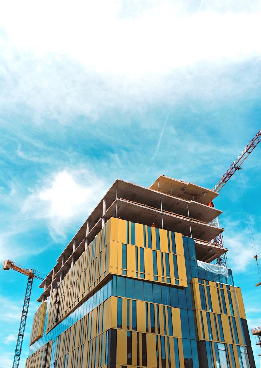 Concrete frame of a mid-rise building under construction against a blue sky